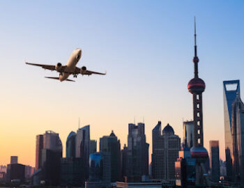 shanghai modern buildings skyline with airplane in sunrise