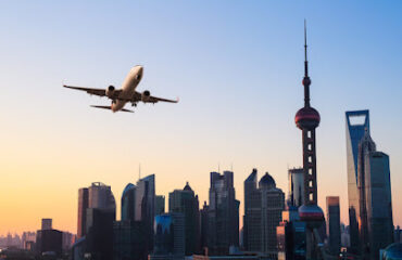 shanghai modern buildings skyline with airplane in sunrise